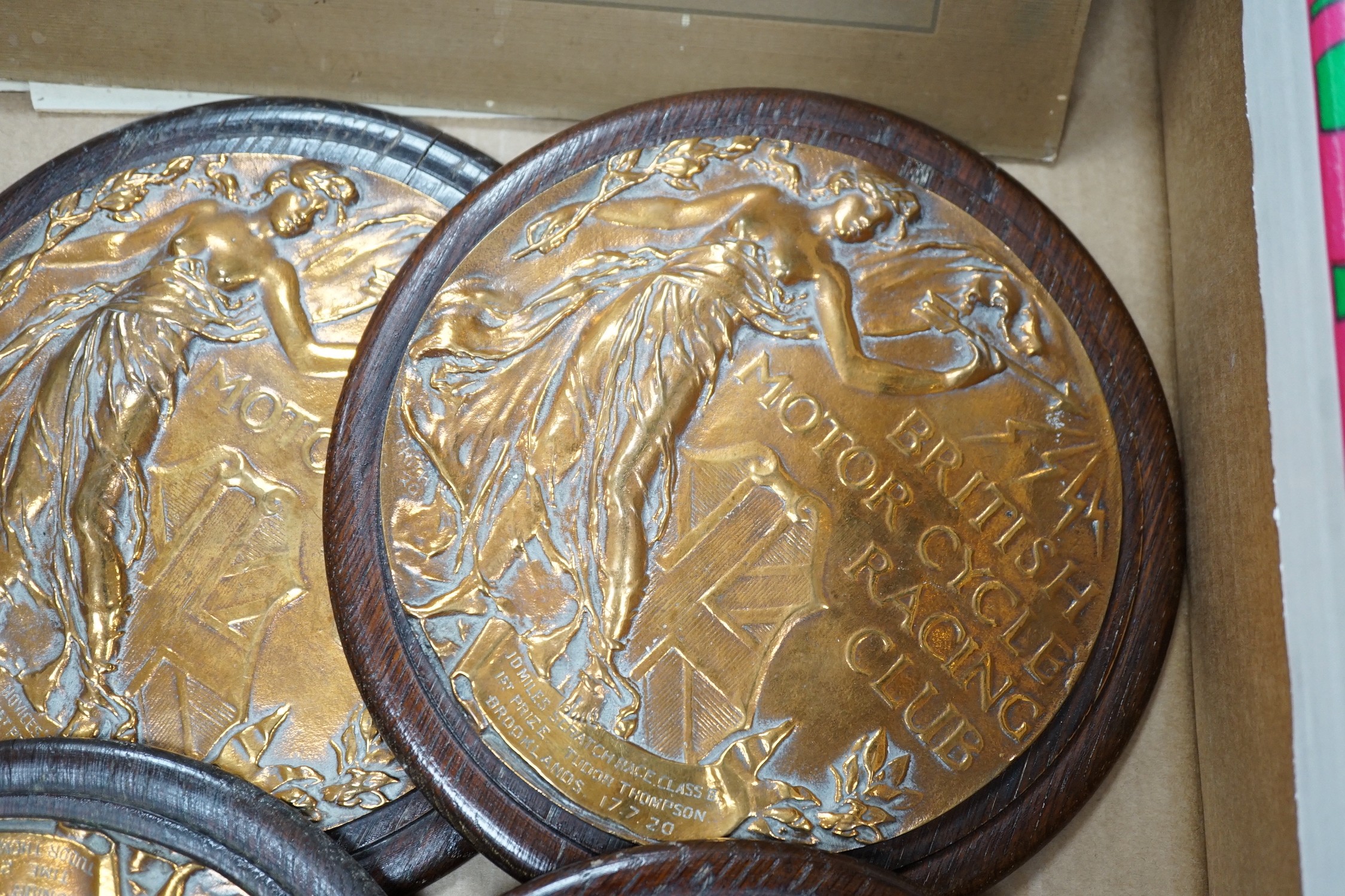 Four circular bronze British Motorcycle Racing Club plaques and related material